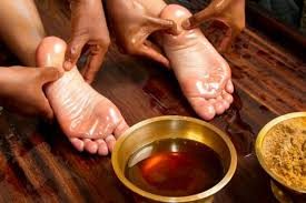 Therapists applying warm medicated oil during an Abhyangam massage at Sattva Healthcare