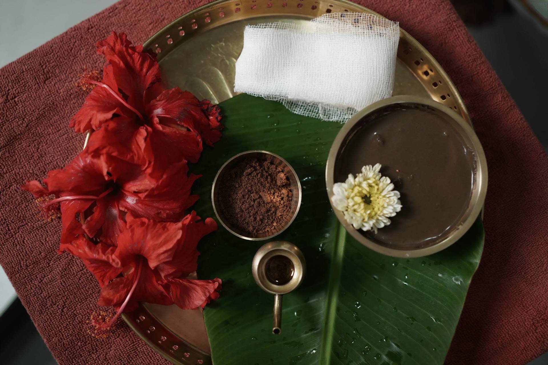 Red hibiscus flower, herbal powder in a bowl and white jasmine flowers